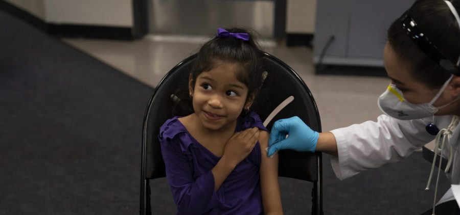 Elsa Estrada, 6, smiles at her mother as pharmacist Sylvia Uong applies an alcohol swab to her arm before administering the Pfizer COVID-19 vaccine at a pediatric vaccine clinic for children ages 5 to 11 set up at Willard Intermediate School in Santa Ana, Calif. Tuesday, Nov. 9, 2021.
