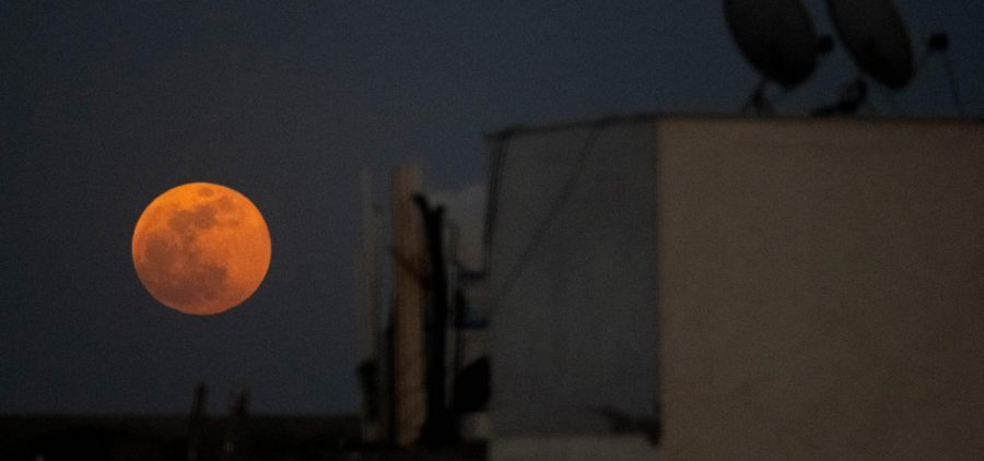 The Super Blood Moon rises over a residential area