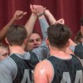 Meigs boys players and their coach raise their arms in a huddle