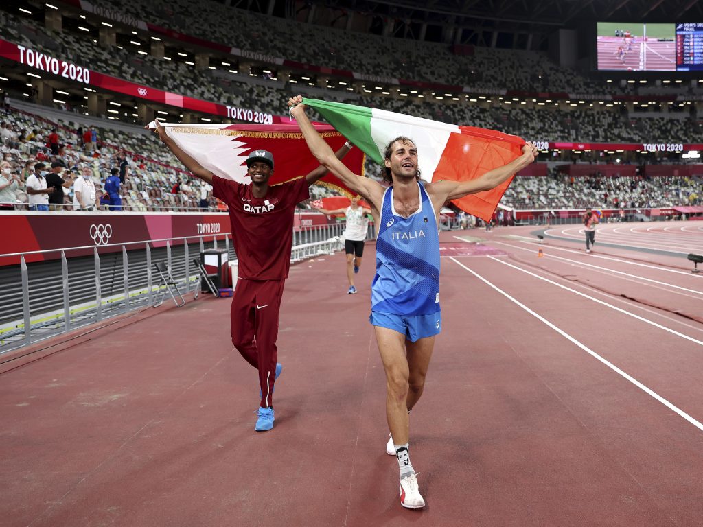 Gold medalists Mutaz Barshim, left, of Qatar, and Gianmarco Tamberi, of Italy, who tied Barshim for gold, celebrate on the track after the final of the men's high jump at the 2020 Summer Olympics, Sunday, Aug. 1, 2021, in Tokyo, Japan.