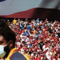 Fans look on as a security guard on the field wears a mask during the game between the Washington Football Team and the Los Angeles Chargers at FedExField