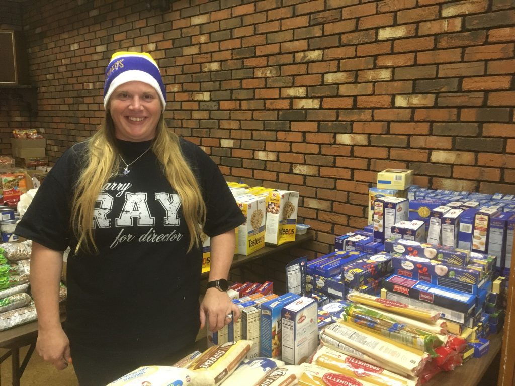 Fran Barker stands inside her union hall with tables full of nonperishable goods