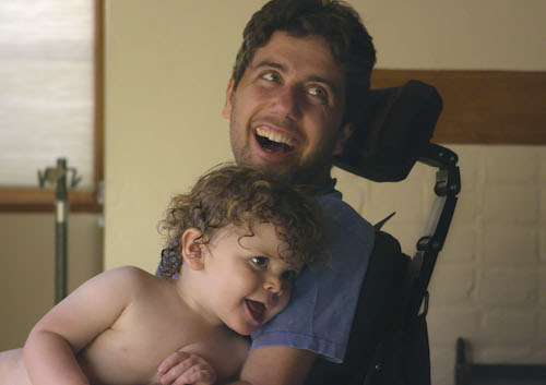 Father in wheelchair holding young daughter