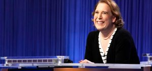 Amy Schneider smiles behind her contestant podium on the set of Jeopardy!