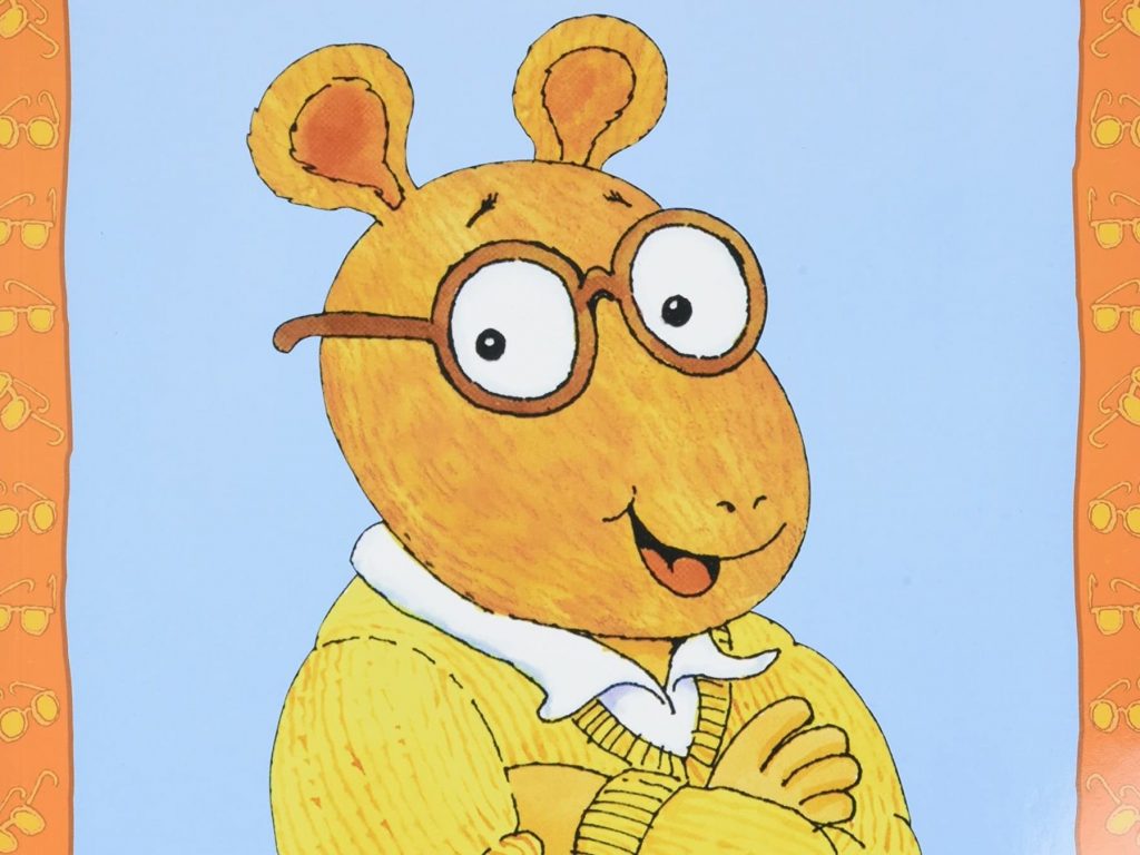 Arthur is drawn posing with his arms crossed and smiling