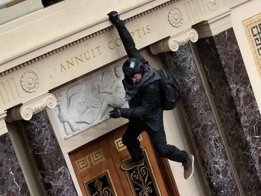 A protester supporting President Donald Trump jumps from the public gallery to the floor of the Senate chamber at the U.S. Capitol on Jan. 06, 2021.