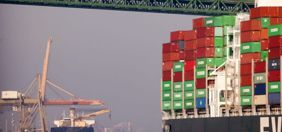 Trucks cross the Vincent Thomas Bridge above a container ship at the Port of Los Angeles on Nov. 30, 2021 in San Pedro, Calif.