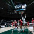 Cece Hooks, number 1, leaps into the air attempting a shot in Ohio University women’s basketball game against Ball State University, in Athens
