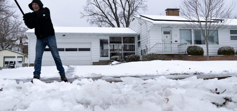 Mark Slagle shovels his parents sidewalk in Athens, Ohio, on Friday, Feb. 4, 2022. “Why did my parents have to buy a double wide lot,” he said with a smile. [Joseph Scheller | WOUB]