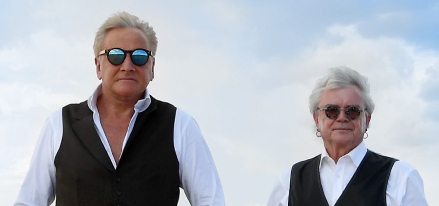Russell Hitchcock and Graham Russell of Air Supply stand in the desert for an Air Supply promotional shoot. Graham Russell has a guitar under his arm.