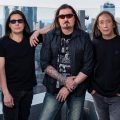 Dream Theater members John Petrucci, Mike Mangini, James LaBrie, John Myung, Jordan Rudess pose on top of a skyscraper for a promotional photo.