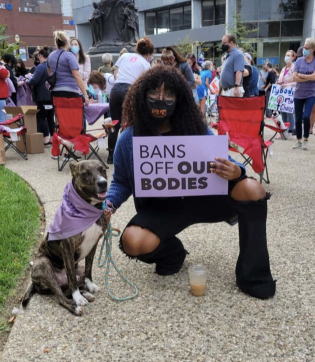 A woman holds a sign reading "Bans off our bodies."