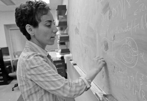 black and white of Maryam Mirzakhani writing on chalkboard