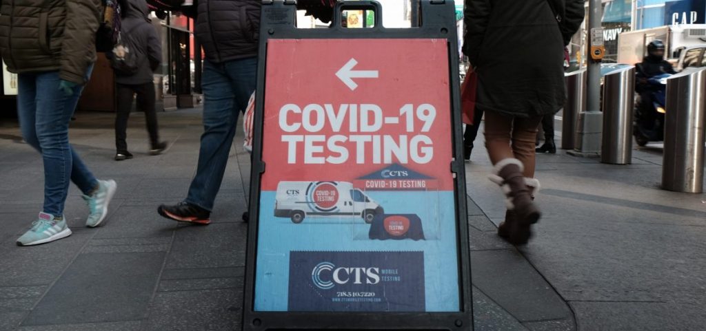 People pass a COVID-19 testing site on a Manhattan street