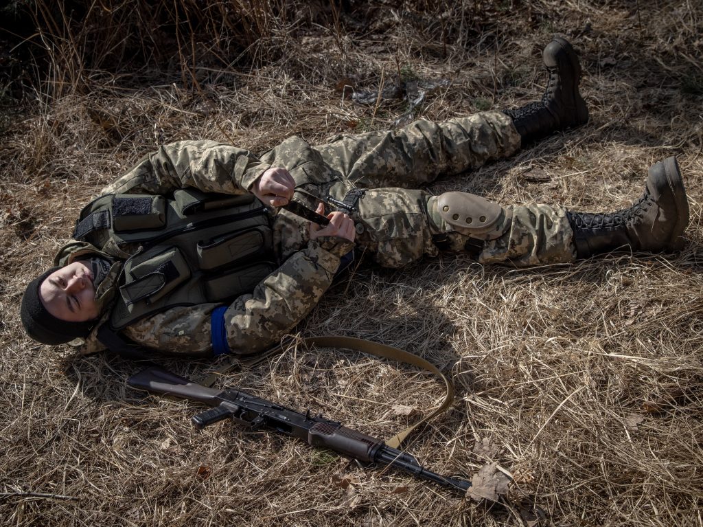A member of a Territorial Defense unit practices putting on a tourniquet at a defensive position on the outskirts of Kyiv on Thursday.