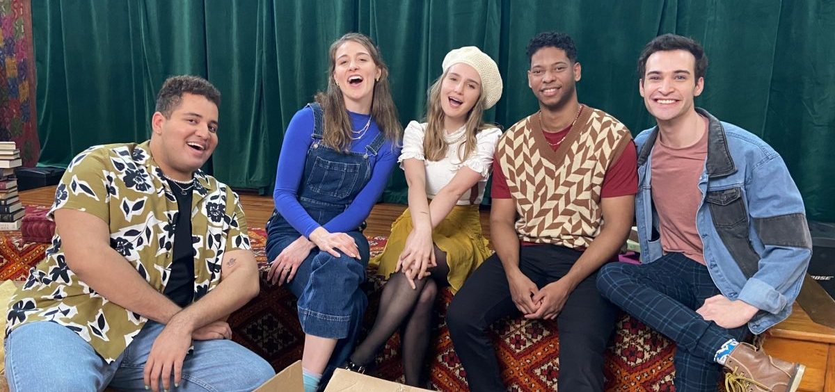 The cast of Reading Rainbow Live sit together on set