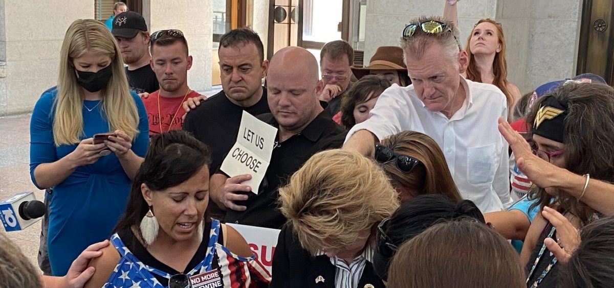 Vaccine mandate opponents pray over Republican Rep. Jennifer Gross at Ohio Statehouse