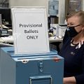 A Delaware County Board of Election worker sits at desk to check voters in during the November 2020 election
