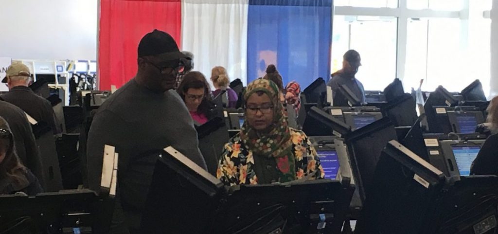 A Franklin County poll worker sets up a machine for an early in-person voter at the county's Early Vote Center