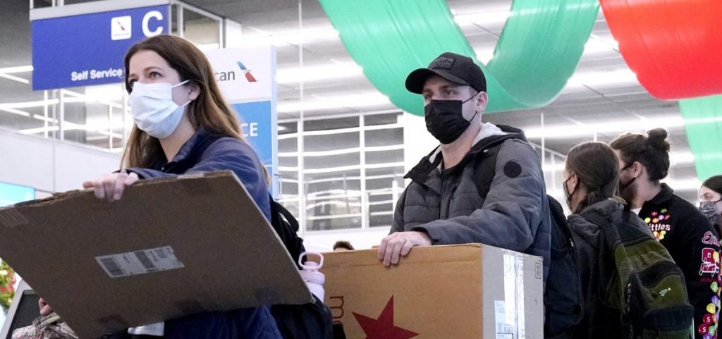 Travelers line up wearing protective masks indoors at O'Hare International Airport in Chicago in December 2021.