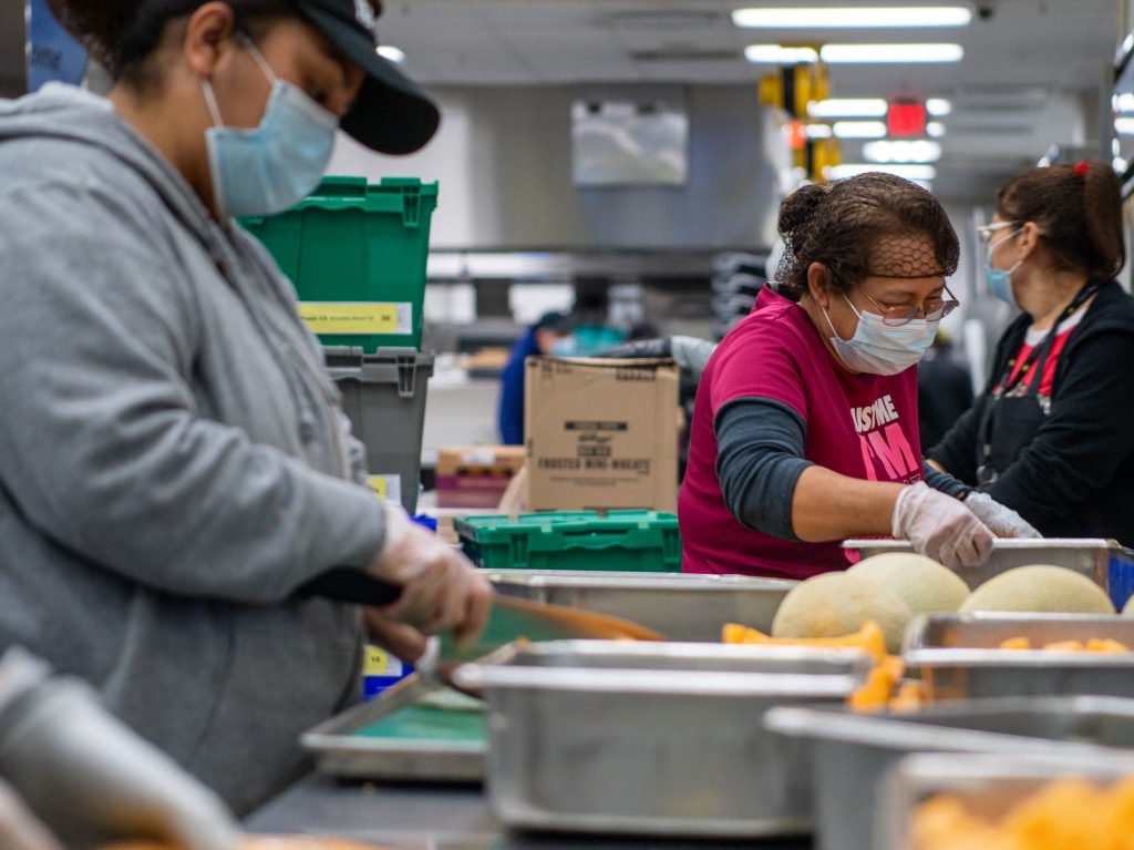 Community volunteers cut and prepare fruit at the Houston Food Bank
