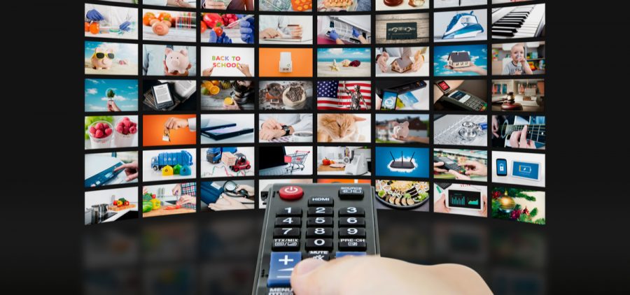 A person points a remote at a tv with a bunch of video in picture in picture