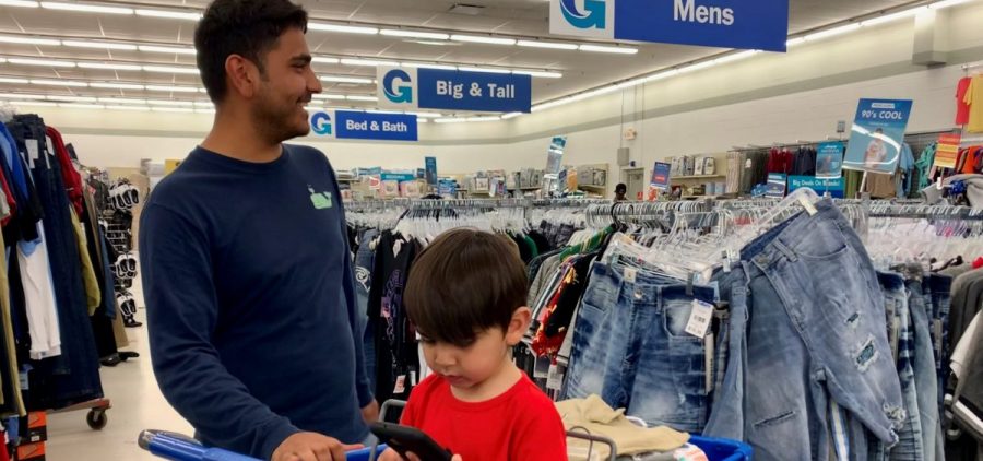 Ruhullah Rezai and his son Farhan shop for clothes after moving to Lexington from Afghanistan.