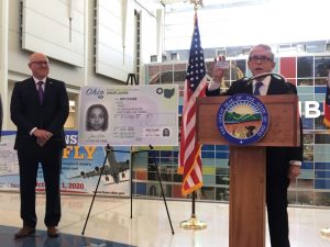 Gov. Mike DeWine shows off his Real ID compliant driver's license at a press conference at John Glenn International Airport in Columbus
