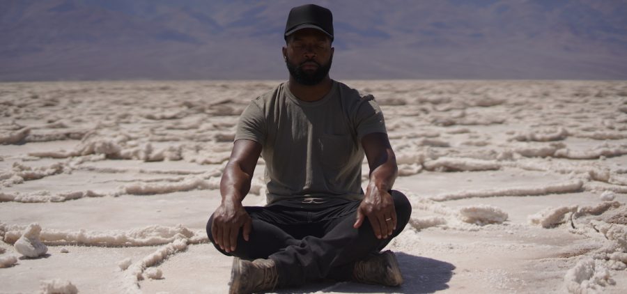 man sitting crossed legged in salt desert