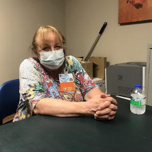 Debbie Wills sits at a table in the Cabin Creek clinic.