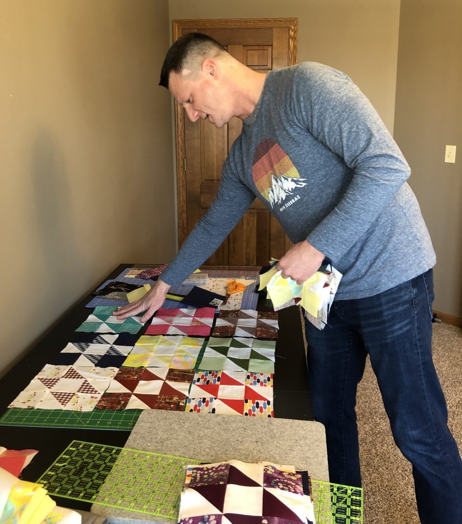 Shane Foster points to pieces that his great-grandmother cut out for a quilt that she never finished. 