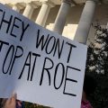 A protester holds a sign at a protest at the Ohio Statehouse