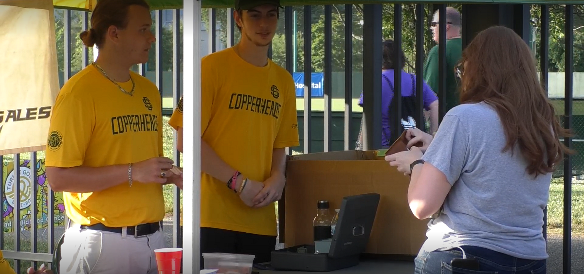 Two Student interns for the Southern Ohio Copperheads working the ticketing desk during July 1 game vs Grand Lake Mariners