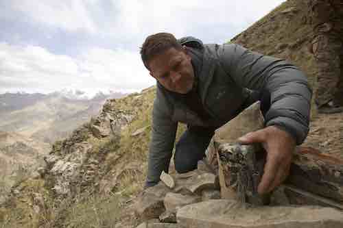 Steve Backshall looking at rocks in mountains of Kyrgyzstan