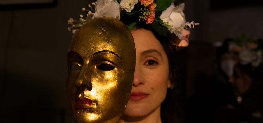 An actress playing Anne Boleyn with gold mask.