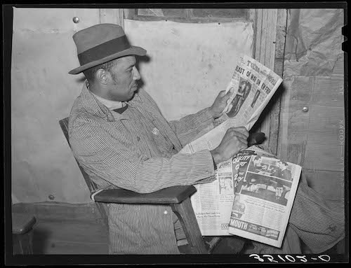 A 1940 Tenant farmer reading newspaper.