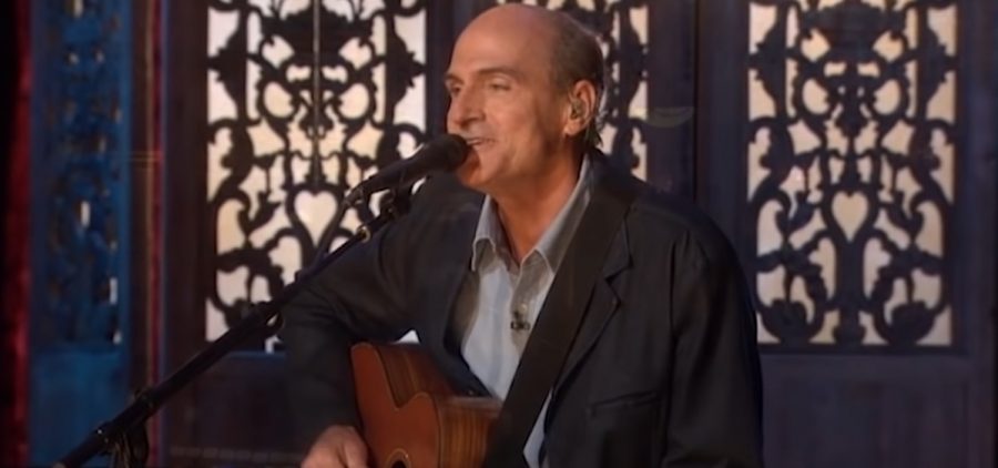 James taylor playing guitar singing into microphone