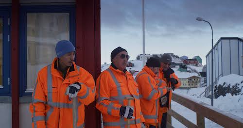 Three Greenland community workers dressed in full orange safety gear- in winter.