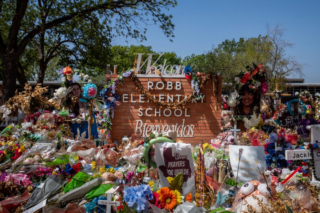 The Robb Elementary School sign is seen covered in flowers and gifts in Uvalde, Texas on June 17.