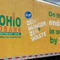 A large semi truck with the words "On the road to ending hunger in our communities by 2025" sits in front of a gray sky..