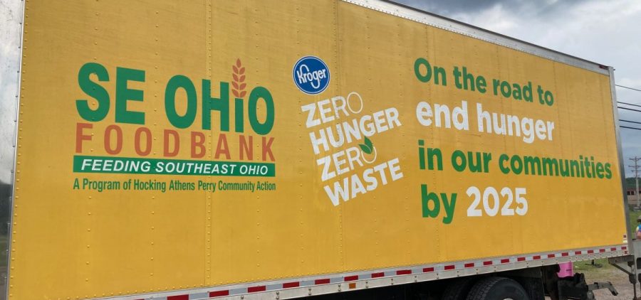 A large semi truck with the words "On the road to ending hunger in our communities by 2025" sits in front of a gray sky..