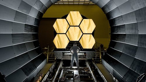 Man standing in front of space solar panels for telescope