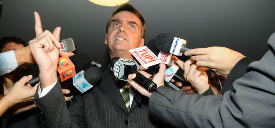 Brazil's President Jair Bolsonaro in 2011 with multiple TV microphones in front of him