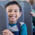 Child smiling at camera on a school bus