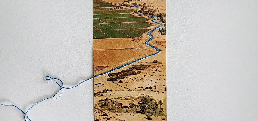 An image of a book whose binding has been undone and artistically altered. There is a winding countryside image, with fields and a winding river.