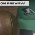 A football and an eastern eagles hat sit upon a desk