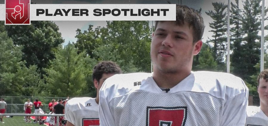 Jackson Logo, "Player Spotlight." Jacob Winters is interviewed in football pads and a practice uniform displaying number 7. Teammates stand behind Winters