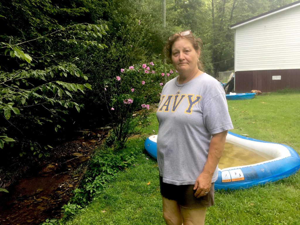 Sally Smith stands in the yard outside of her home.