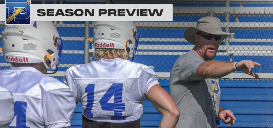 Philo Head coach points while explaining to football players in Philo practice uniforms