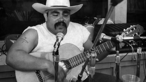 Singer Ramon “Chunky” Sanchez at microphone with guitar,circa 1974